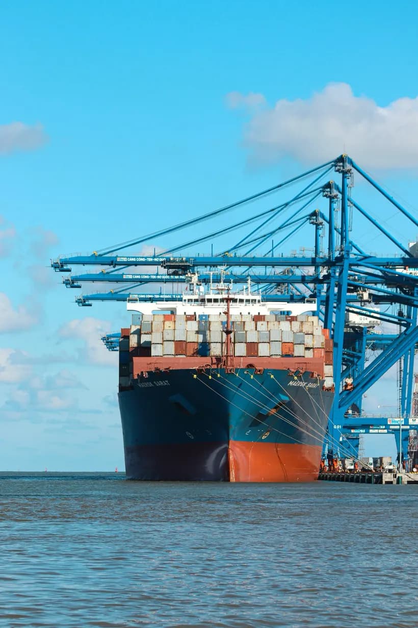 Loaded container ship berthed under ship-to-shore cranes
